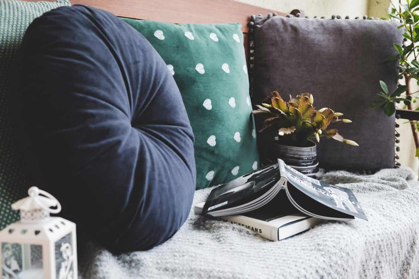 Three cushions, some books, and a house plant for budget ways to do up your living room.