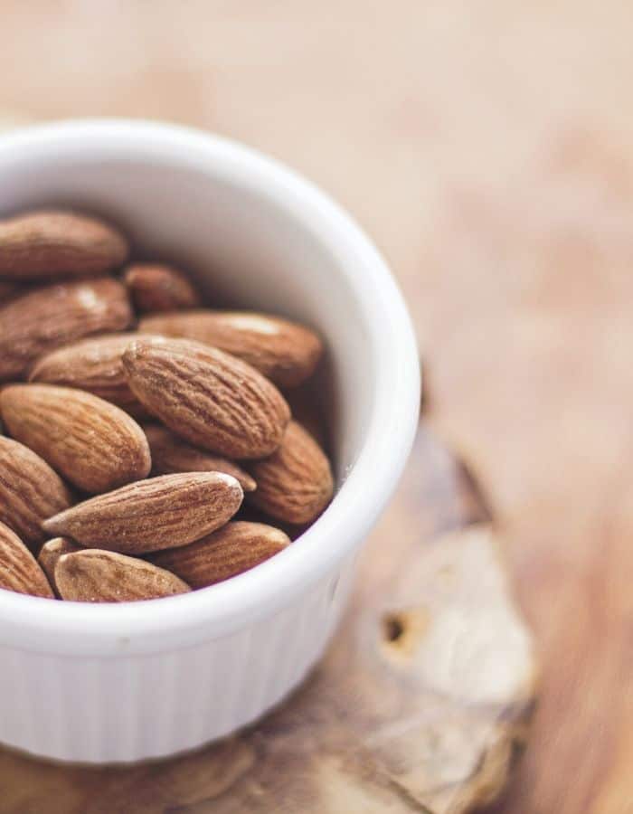 small white bowl with whole almonds