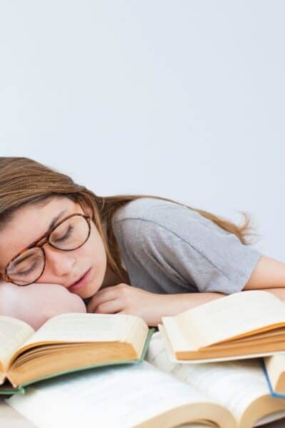 student sleeping on books